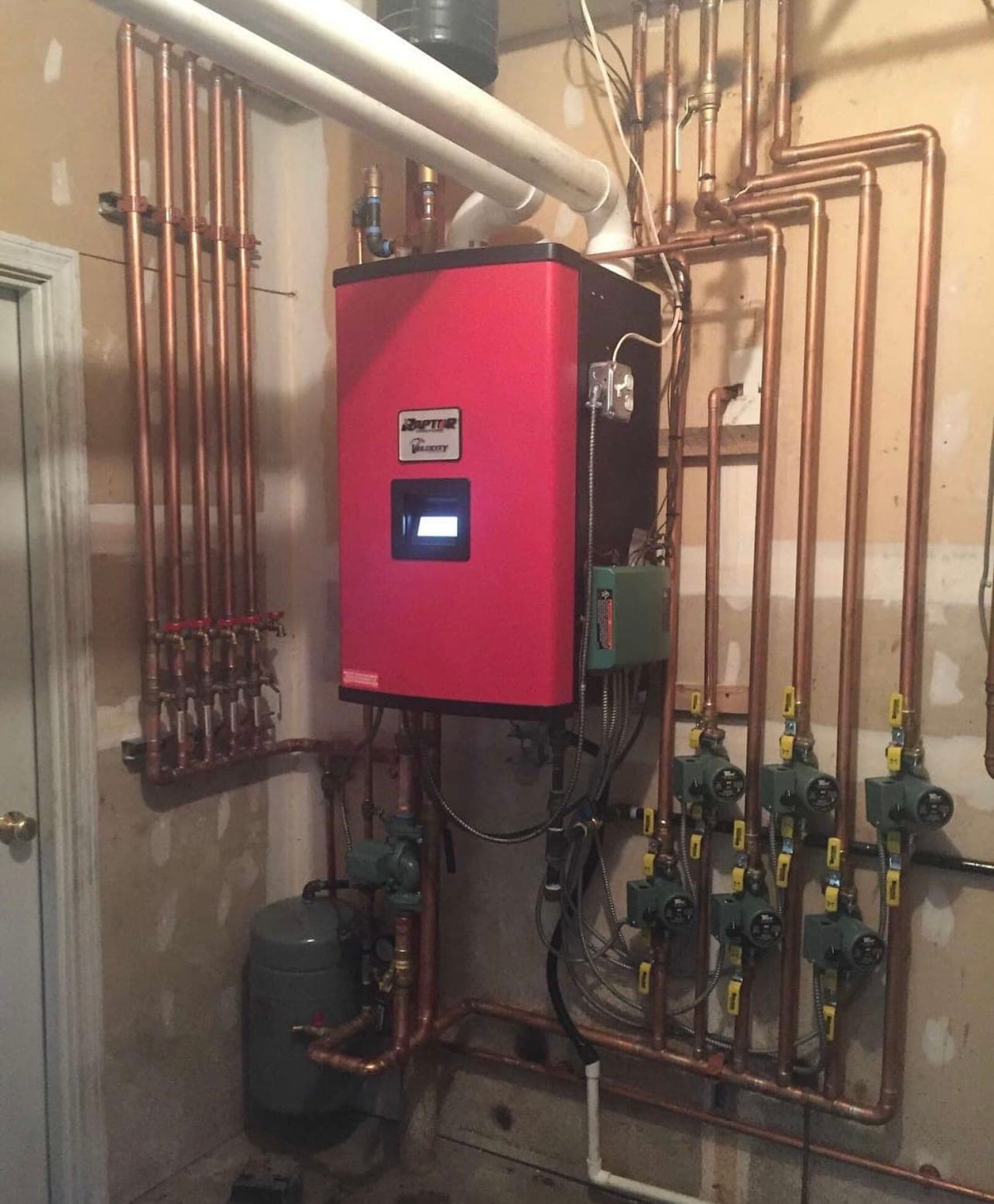 Wall-hung boiler with zone valves and copper manifold installed by Classic Climate Controls
